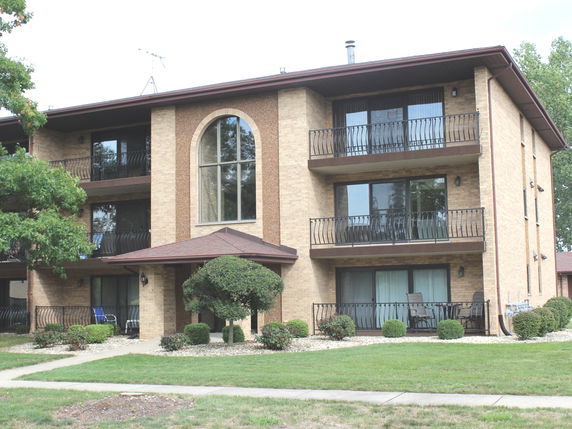 Front view of a multi-story apartment building with balconies.