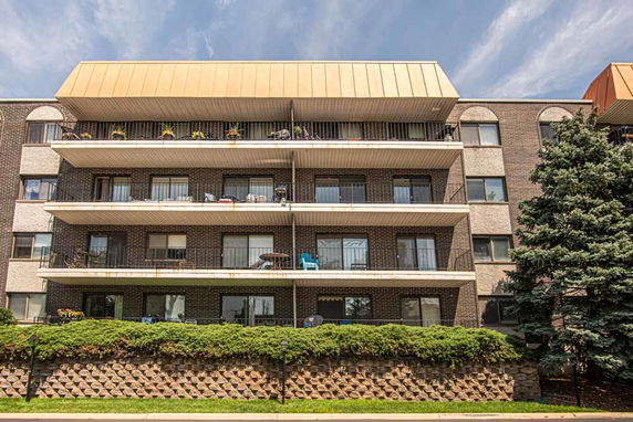Front view of a multi-story apartment building with balconies.