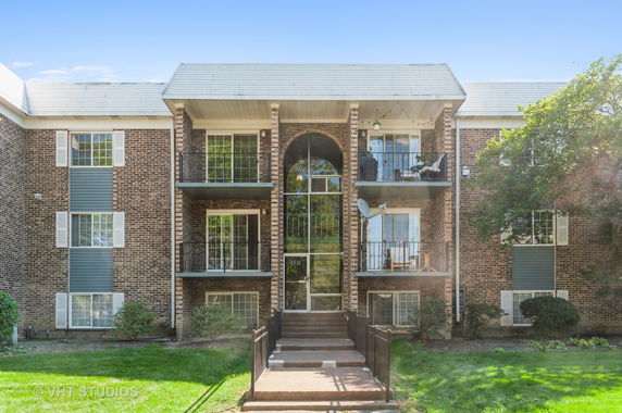 Front view of a multi-story apartment building with balconies.