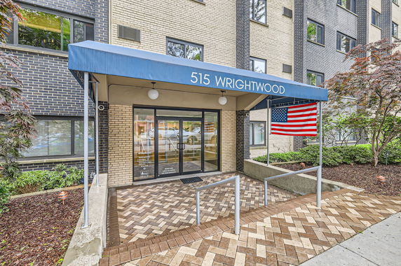 Front view of a building entrance with an awning labeled '515 Wrightwood' and an American flag.