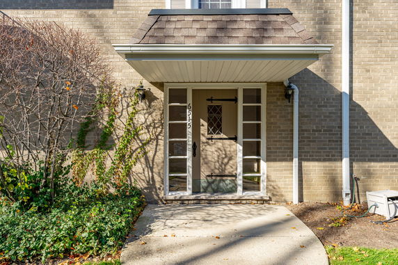 Front view of a house entrance with a small porch and decorative door.