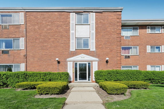 Front view of a brick apartment building with multiple windows.