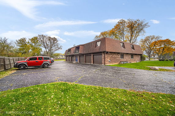 Front view of a two-story brick building with a distinct roof and garage entrances.