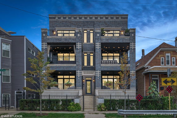 Front view of a modern multi-story residential building with balconies.