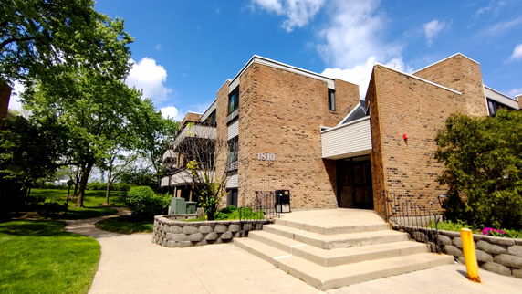 Front view of a two-story brick building with steps leading to the entrance.