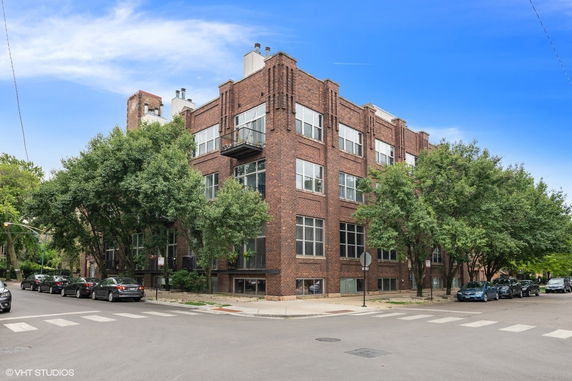 Front view of a multi-story brick apartment building on a corner lot.