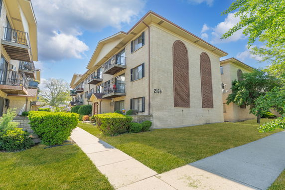 Front view of a multi-story apartment building with balconies.