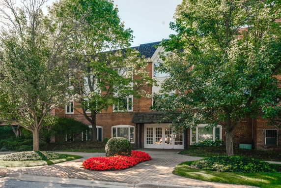 Front view of a multi-story building with brick facade and white framed windows.
