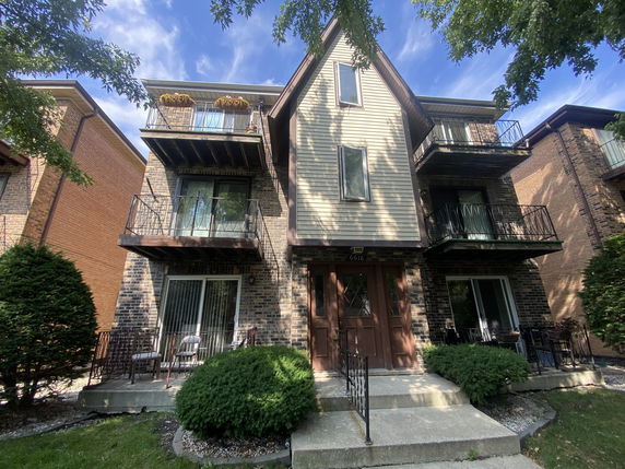 Front view of a multi-story residential building with balconies.