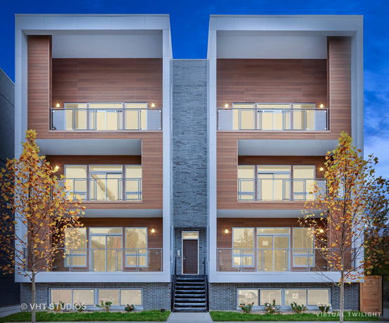 Front view of a modern multi-story residential building with large balconies.