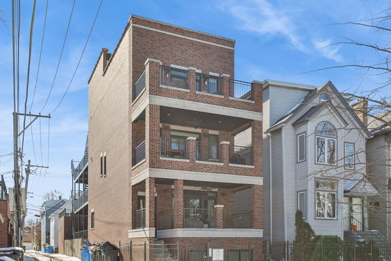Front view of a multi-story brick building with balconies.