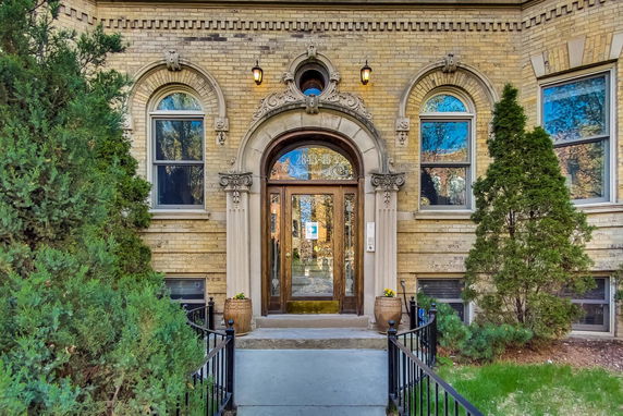 Front view of a brick building with an ornate entrance and arched windows