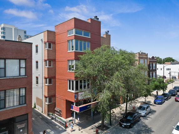 Front view of a multi-story red brick building on a city street.
