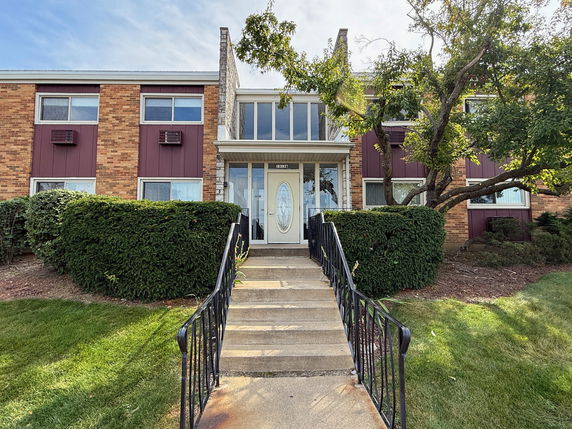 Front view of a two-story building with brick facade and central entrance.