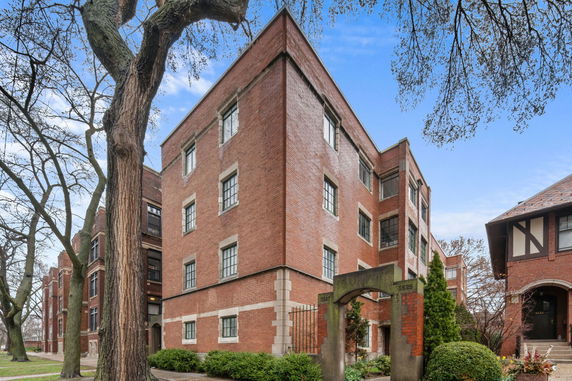 Front view of a multi-story brick building with multiple windows.