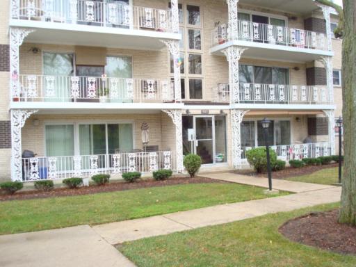 Front view of a multi-story apartment building with balconies and decorative railings.