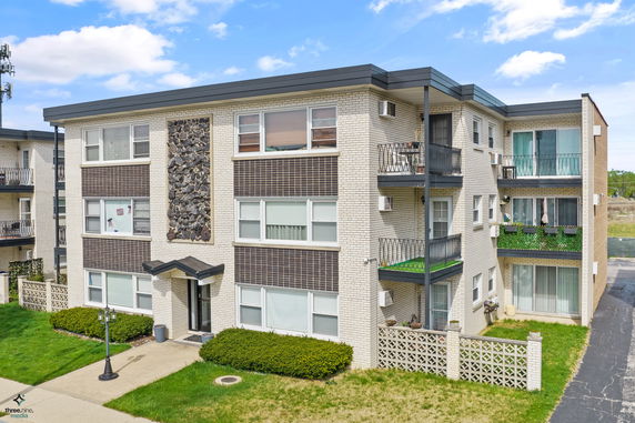 Front view of a three-story apartment building with balconies.