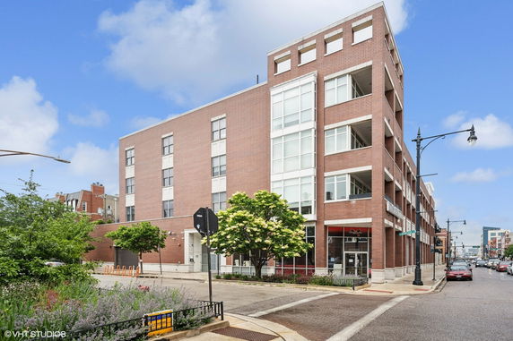 Front view of a multi-story brick building on a street corner.