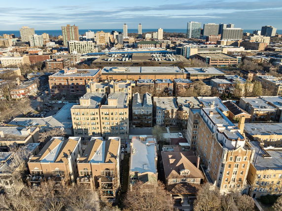 Panoramic view of a city's residential and commercial buildings with taller structures in the background.
