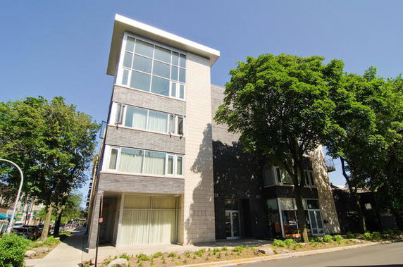 Front view of a modern multi-story building with large windows.