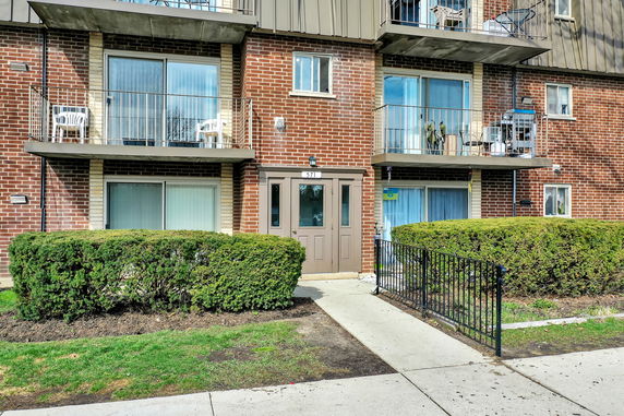 Front view of a brick apartment building with balconies.