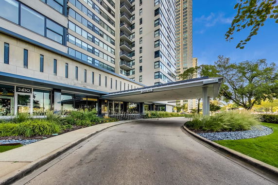 Front view of a multi-story residential building with a driveway entrance.