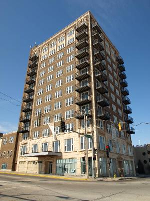 Front view of a multi-story building with balconies and large windows.