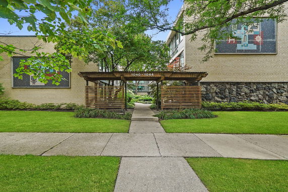 Front view of a building with wooden pergola entrance.