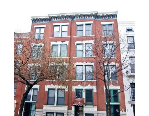 Front view of a multi-story brick building with multiple windows.