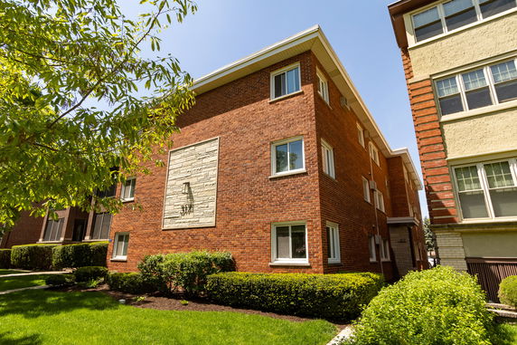 Front view of a multi-story brick apartment building.