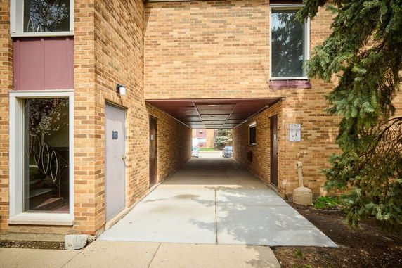 View of a brick building with a passageway leading through it.