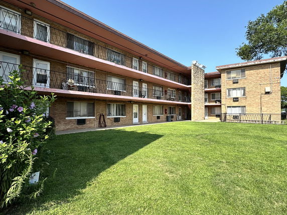Front view of a multi-story apartment building with external balconies.