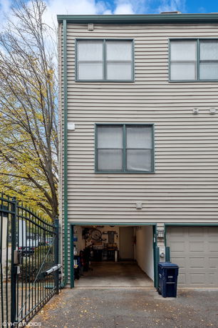 Front view of a multi-story house with garage and windows.