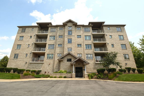 Front view of a multi-story apartment building with balconies.