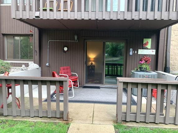 Front view of a building with a patio area and sliding glass door entry.