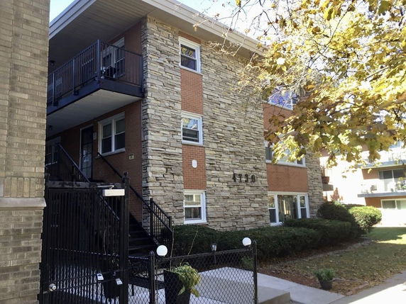 Front view of a multi-story building with brick and stone facade.