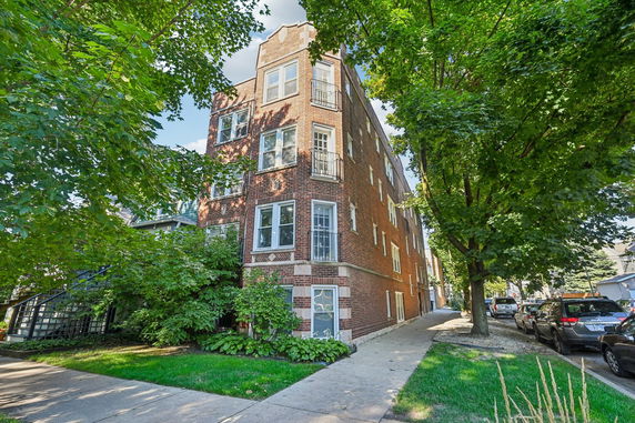Front view of a multi-story brick apartment building.