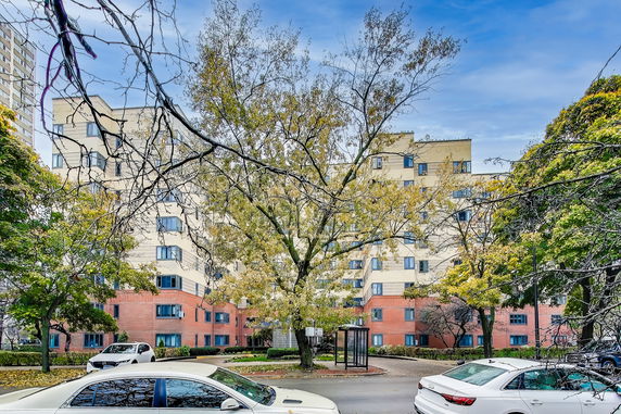 Front view of a multi-story residential building with red and beige facade.