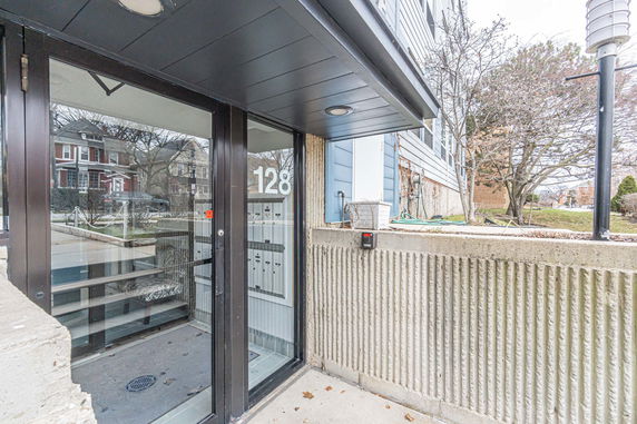 Entrance view of a building with glass doors and visible mailboxes inside.