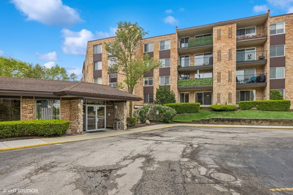 Front view of a multi-story apartment building with balconies.