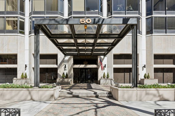 Front view of a building with large windows and a glass canopy entrance.