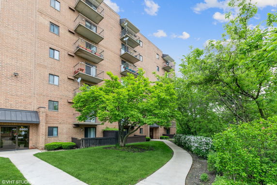 Front view of a multi-story brick apartment building with balconies.