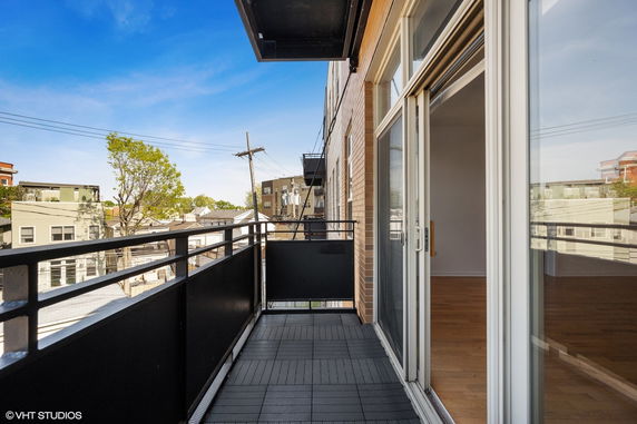 Balcony with railing overlooking surrounding buildings.