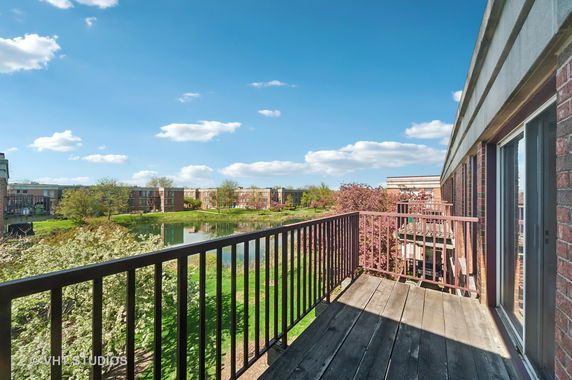 View from a balcony overlooking a pond and surrounding residential buildings.