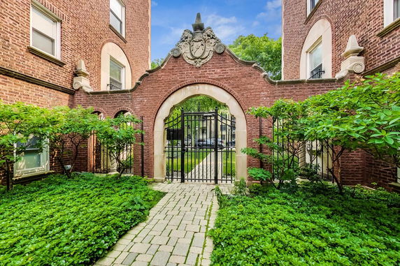Front view of a brick building with decorative arch gate.