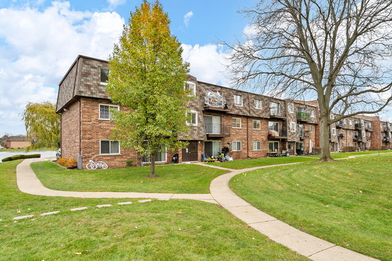 Front view of a three-story apartment building with balconies.
