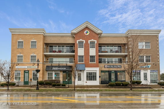 Front view of a mixed-use building with shops and residential balconies.