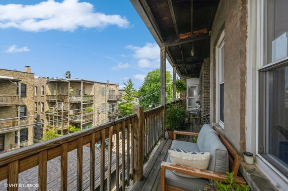 View from a balcony showing adjacent apartment buildings with external staircases.