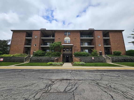 Front view of a multi-story brick apartment building.