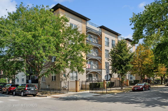 Front view of a multi-story apartment building with balconies.